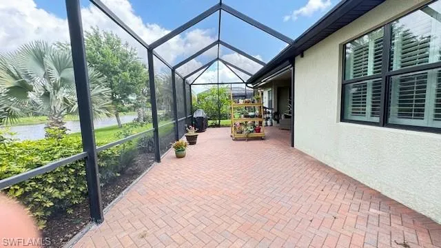View of patio featuring extended screen enclosure and a water view.