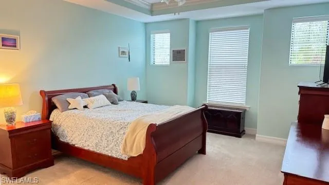Carpeted bedroom featuring multiple windows and ornamental molding
