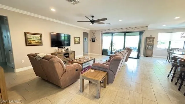 Living room featuring ceiling fan and crown molding