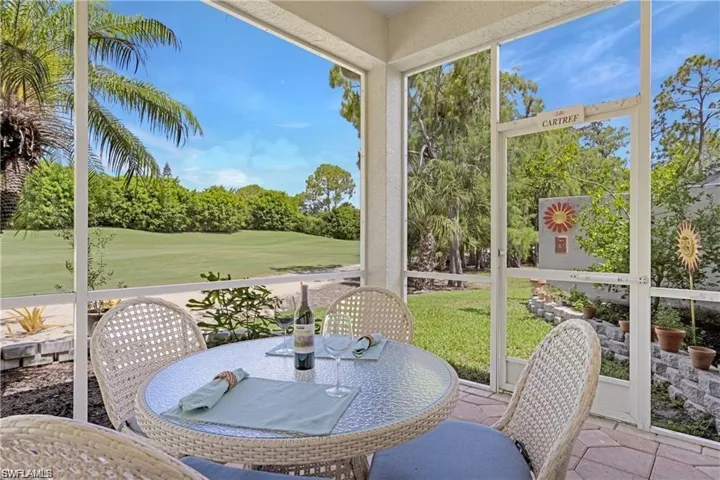 Sunroom / solarium with outdoor dining area, golf course view, and view of scattered trees