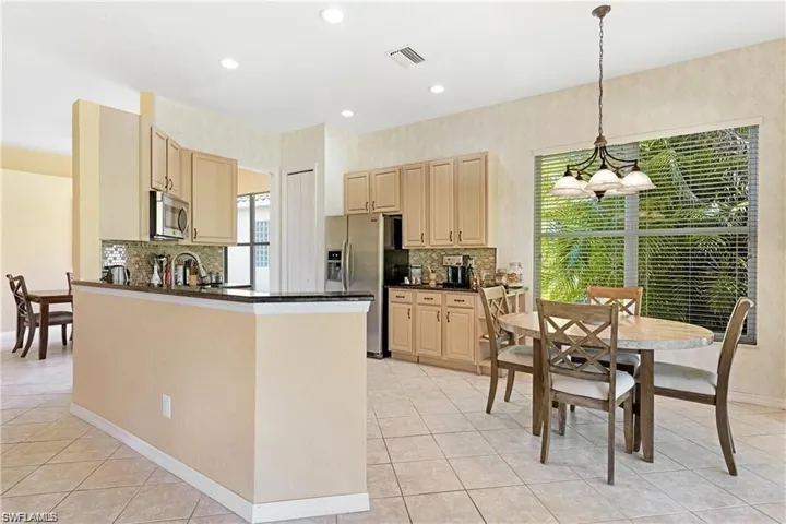 Kitchen with stainless steel appliances, light wood finish cabinetry, and a peninsula