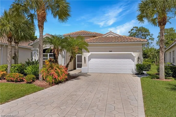 Mediterranean / spanish-style home with a garage, driveway, stucco siding, a tiled roof, and a front yard