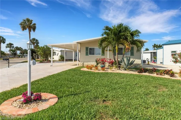 View of front of house featuring a front lawn and a carport