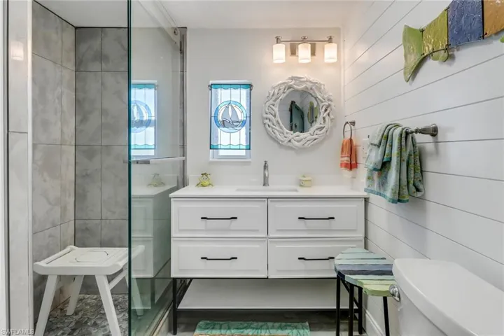 Bathroom featuring wood walls, vanity, and toilet