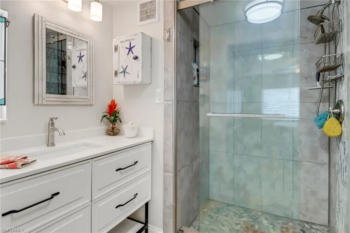 Bathroom featuring oversized vanity and a shower with door