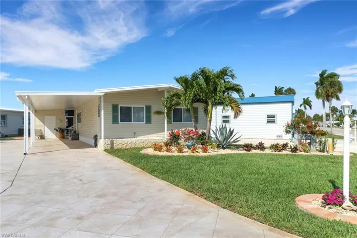 View of front of property with a front yard and a carport