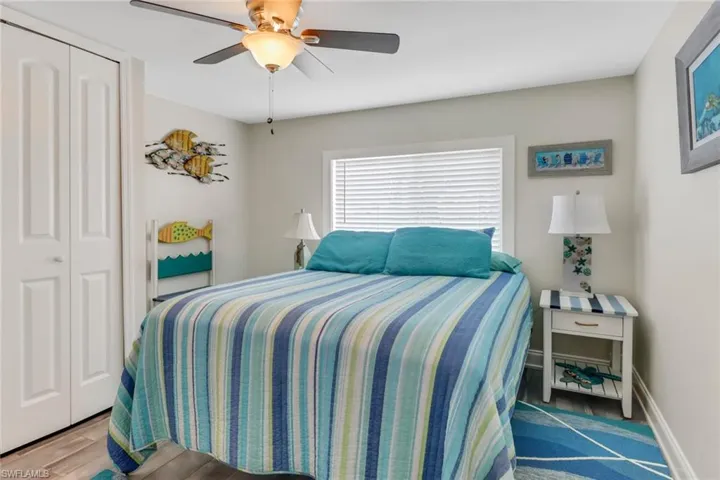 Bedroom with hardwood / wood-style floors, a closet, and ceiling fan