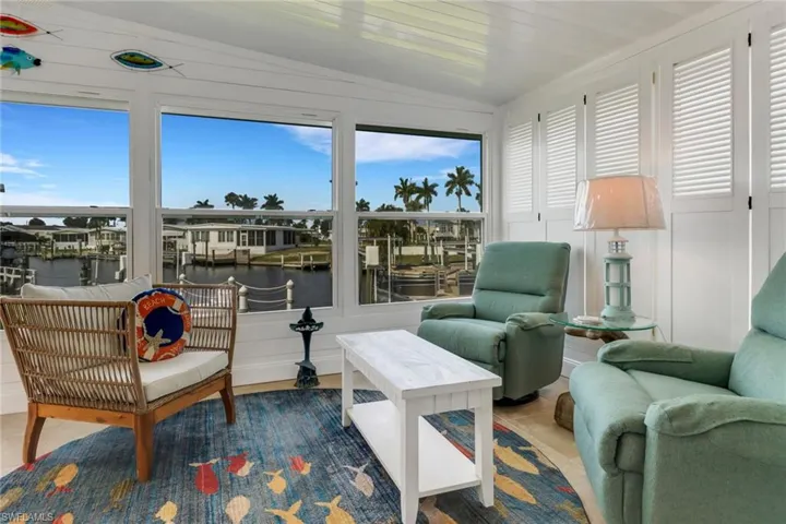 Sunroom featuring a water view and lofted ceiling