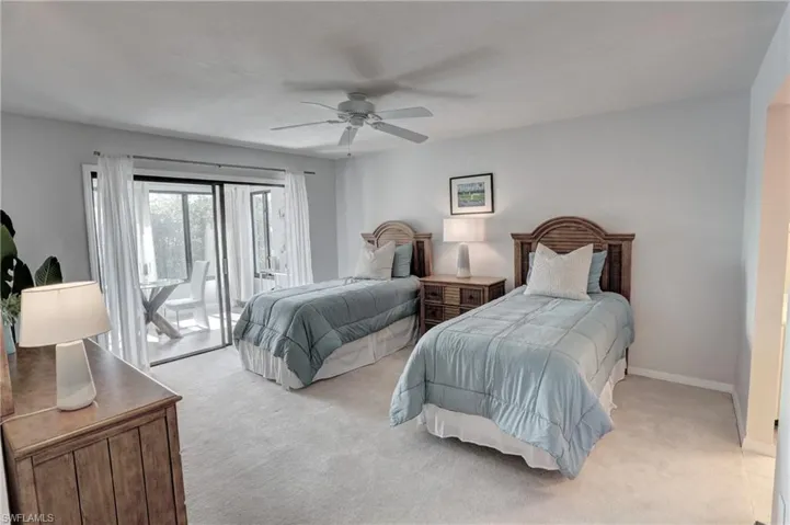Carpeted bedroom with access to exterior sunroom and ceiling fan