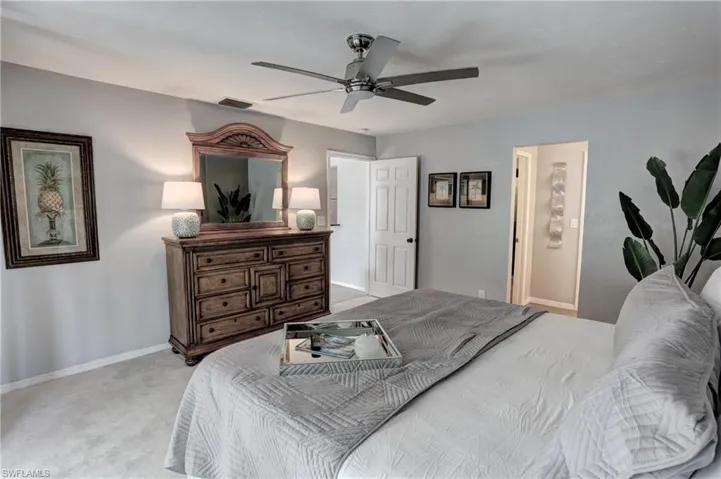 Carpeted bedroom featuring ceiling fan
