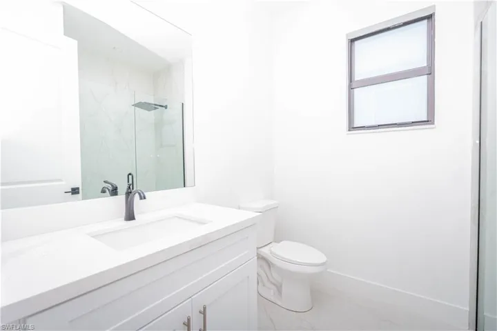 Bathroom with vanity and a marble finish shower
