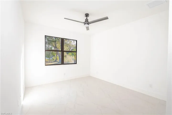 Spare room featuring marble finish flooring and ceiling fan