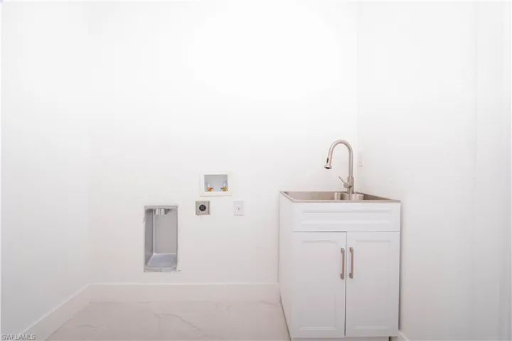Laundry area with washer hookup and cabinet space