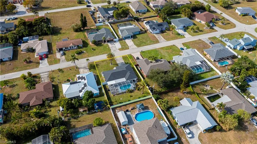 Aerial view of property's location with nearby suburban area and a pool area
