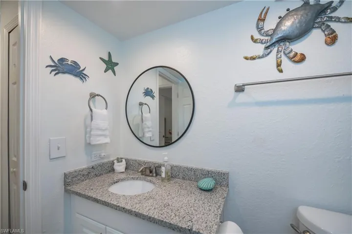 Half bath featuring vanity and a textured wall