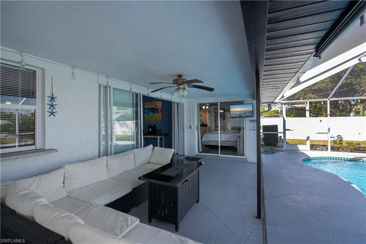 View of patio featuring a sunroom, glass enclosure, an outdoor living space, and a ceiling fan