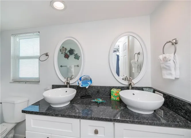 Full bathroom featuring double vanity and toilet