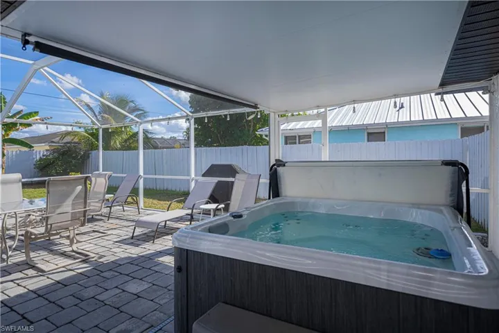 Fenced backyard with  enclosure, a hot tub, a patio area, and area for grilling