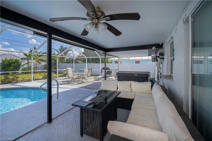 Swimming pool featuring an outdoor living space, a hot tub, a patio area, a sunroom, and screened enclosure