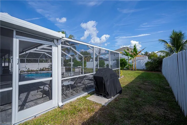 Fenced backyard with a lanai, a patio, and a sunroom