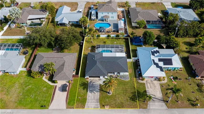 Aerial view of residential area featuring a pool area and property parcel outlined