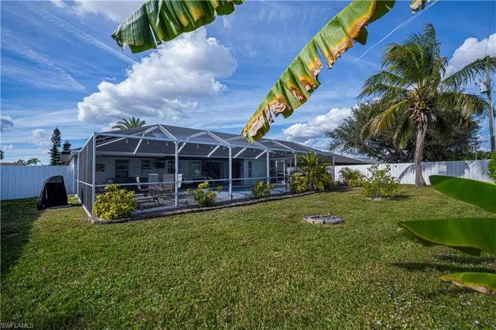Fenced backyard featuring a lanai, a sunroom, and a pool