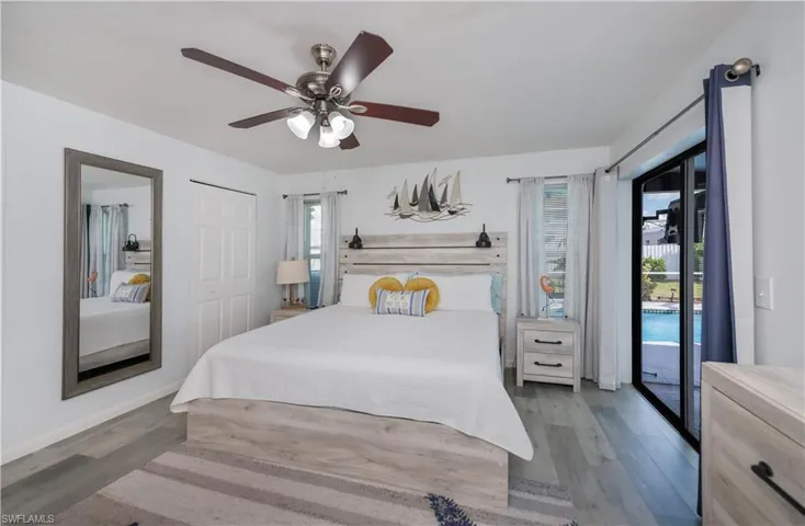Bedroom featuring access to outside, wood finished floors, and a ceiling fan