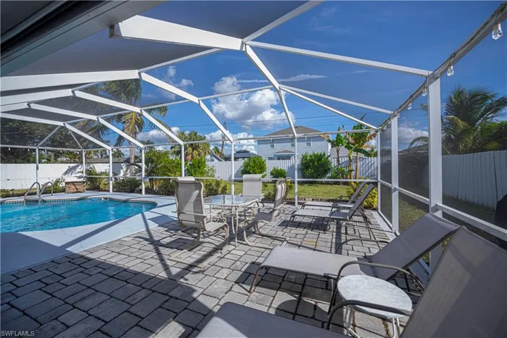 View of pool featuring a lanai, a fenced backyard, a sunroom, and a patio