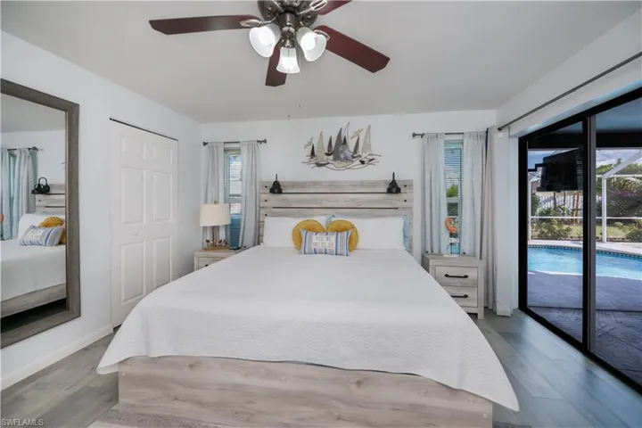 Bedroom featuring access to exterior, a ceiling fan, wood finished floors, and a closet