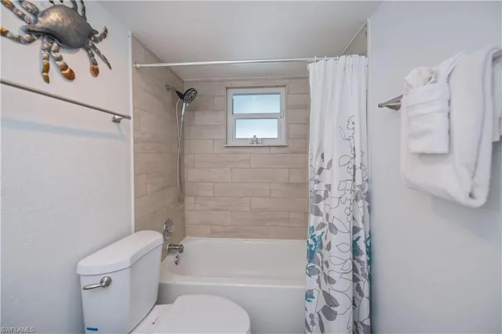 Bathroom with toilet and shower / bath combo with shower curtain