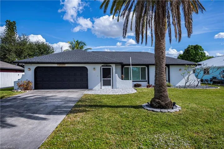 Single story home with stucco siding, driveway, a front yard, an attached garage, and roof with shingles