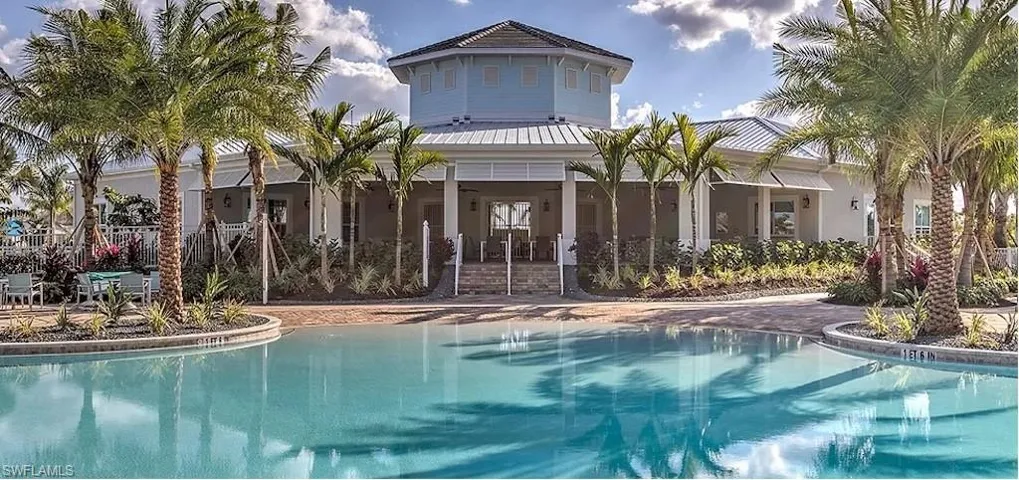 Back of house with a community pool, a metal roof, and stucco siding