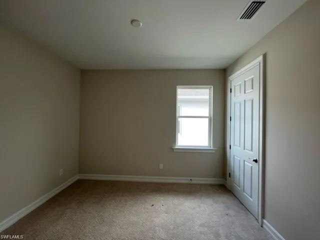 Unfurnished bedroom featuring carpet and baseboards