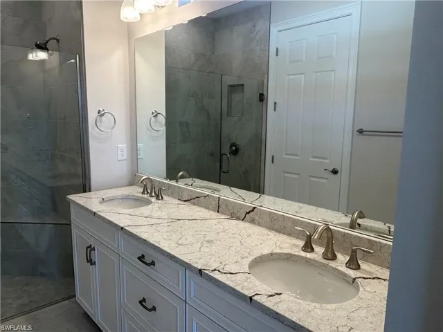 Full bath with double vanity and a stall shower