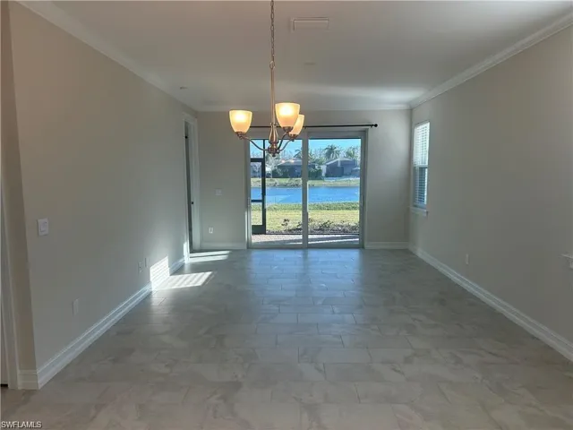 Unfurnished dining area with a chandelier, ornamental molding, and a water view