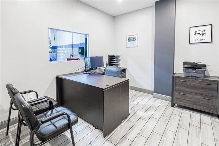 Light-toned tile flooring, white wall finishes, accent wall paneling, and an interior pass-through window