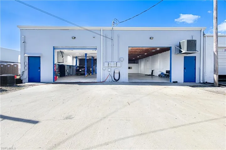 Commercial structure featuring two large bay doors, two pedestrian doors, and a concrete lot