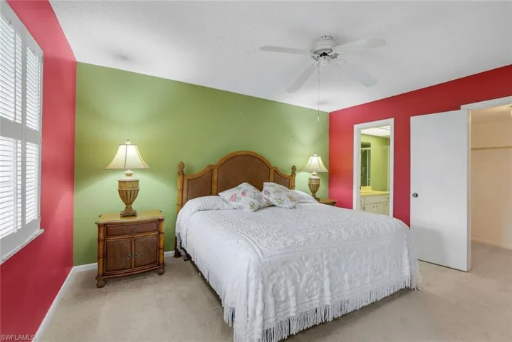 Primary bedroom with ensuite bathroom, walk in closet, ceiling fan, and delightful natural light