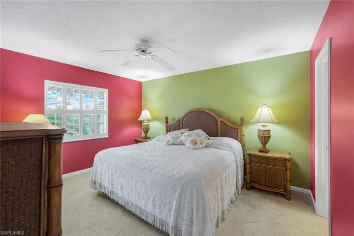 Primary bedroom offers serene view of water through both the magnificent window and sliding glass door onto the lanai