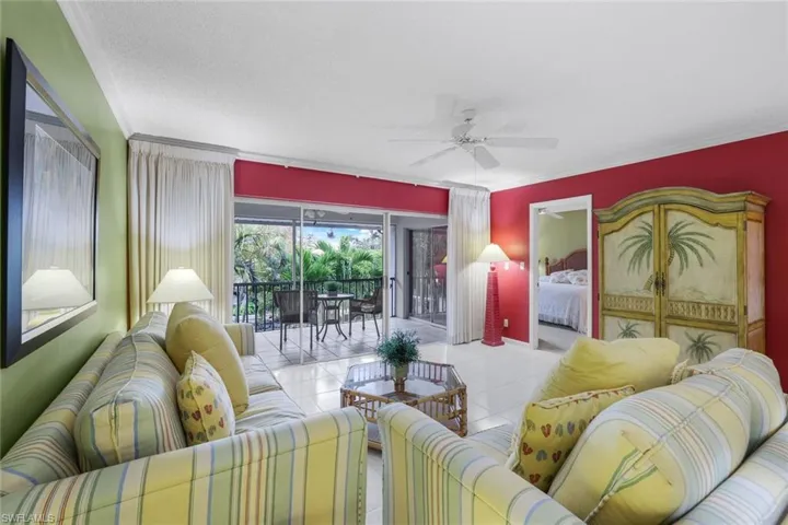 Living room featuring crown molding, light tile patterned floors, ceiling fan, and a view of the lanai