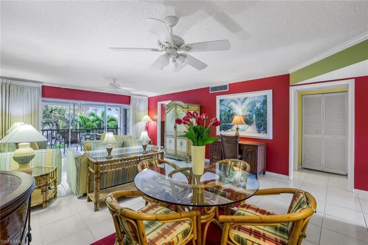 The dining and living room areas are tiled throughout and feature crown molding, a textured ceiling, and ceiling fans