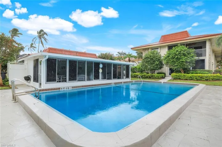 Community swimming pool featuring a patio area, community room, and custom awnings