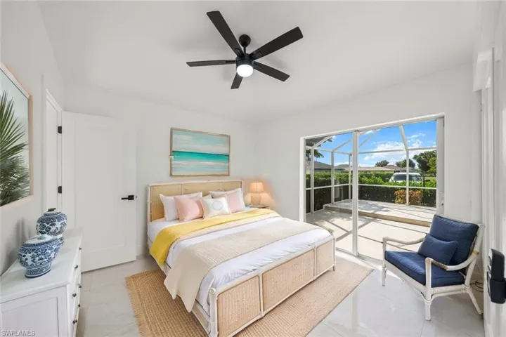 Bedroom with access to exterior, ceiling fan, light tile patterned floors, and a sunroom