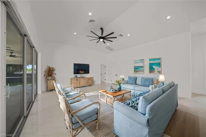 Living area with ceiling fan, lofted ceiling, and recessed lighting
