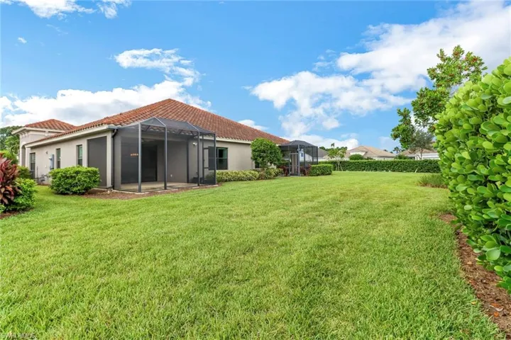 View of green lawn featuring a lanai and a patio area