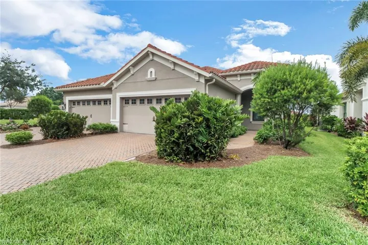 Mediterranean / spanish home with stucco siding, an attached garage, decorative driveway, a tile roof, and a front lawn