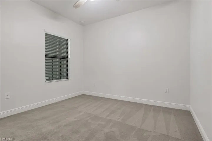 Unfurnished room with light colored carpet and a ceiling fan