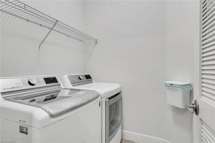 Laundry area with washing machine and dryer and baseboards