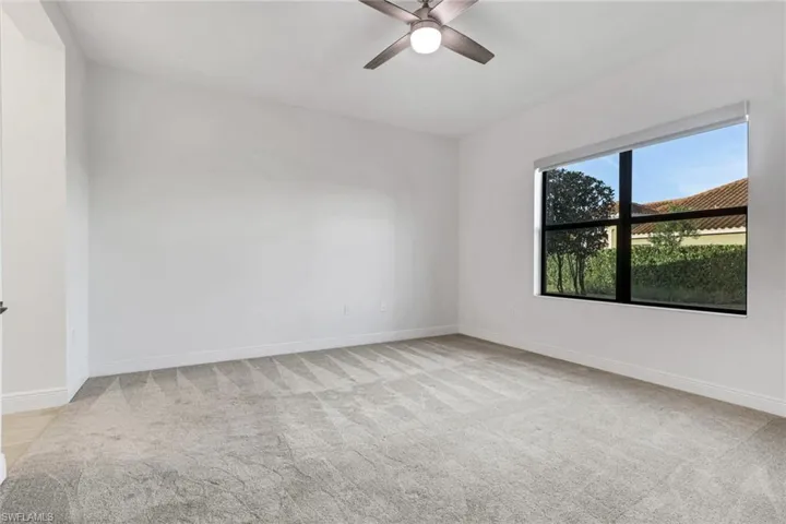 Unfurnished room with light colored carpet and a ceiling fan