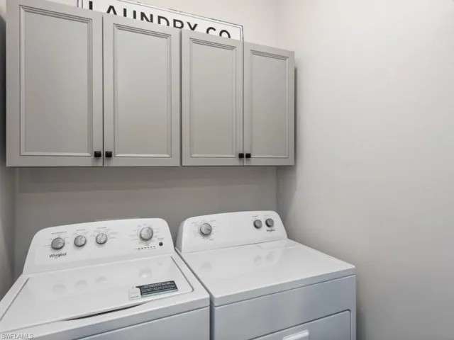 Laundry room with separate washer and dryer and cabinet space